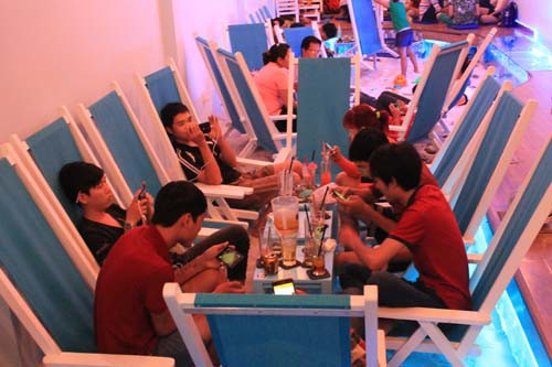 Phòng sau trang trí theo phong cách bãi biển đích thực, với cát trắng tinh nhập từ Nha Trang, những bể cá lớn sắc màu cùng với bàn ghế màu xanh dương. Khách có thể nằm dài thư giãn như đang tắm nắng ngoài bờ biển.