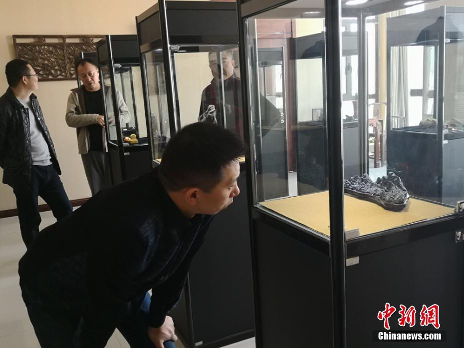 Khách tham quan chăm chú chiêm ngưỡng những cổ vật được trưng bày trong tủ kính.