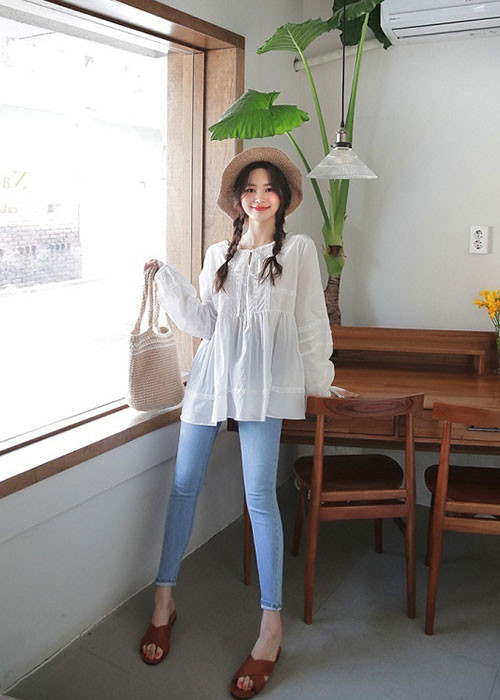 Các bạn gái sẽ có diện mạo bay bổng nữ tính khi diện áo sơ mi cách điệu buộc dây cổ với tông trắng ngọt ngào để mix cùng quần skinny jean và các phụ kiện xinh yêu như dép lê, mũ cói và túi cói.