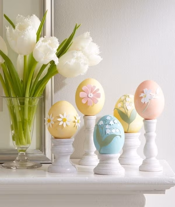 Những quả trứng nhỏ xíu được tô những gam màu nhẹ nhàng. Bạn có thể dán thêm những hình hoa lá bằng giấy vào những quả trứng mới tô màu và khéo léo đặt chúng trên chiếc đế màu trắng đơn giản để có được góc nhỏ xinh xắn trang trí cho ngôi nhà của bạn.