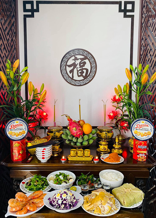 Mâm cỗ cúng ông Công ông Táo của gia đình Hạ Vy gồm có cơm trắng, bánh chưng, gà lộc, salad, tôm, rau xào, xôi gấc tạo hình cá.