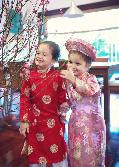 Hồng Nhung rất hạnh phúc khi nhìn hai con mặc tà áo truyền thống. Ảnh: Khám phá