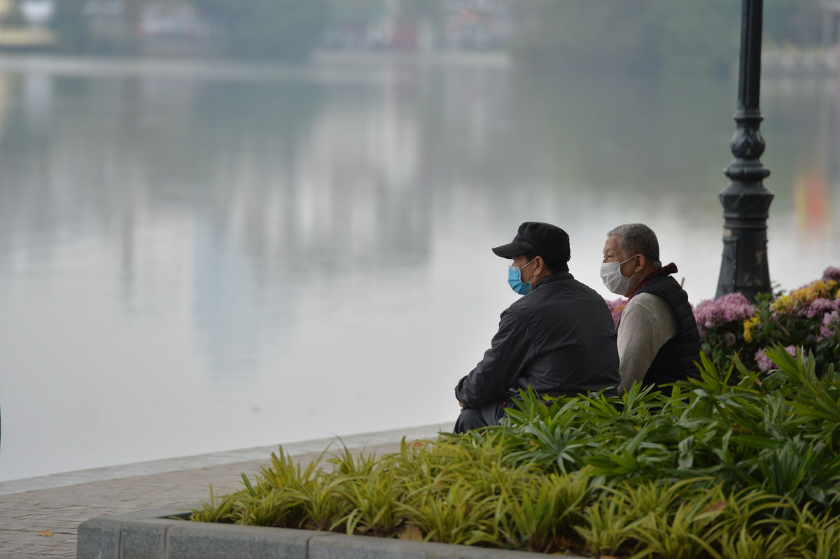 Hai cụ ông đeo khẩu trang ngắm hồ Hoàn Kiếm.