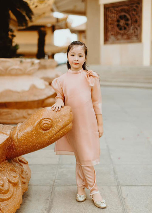 Cô nhóc tự tin tạo dáng trong trang phục áo dài.