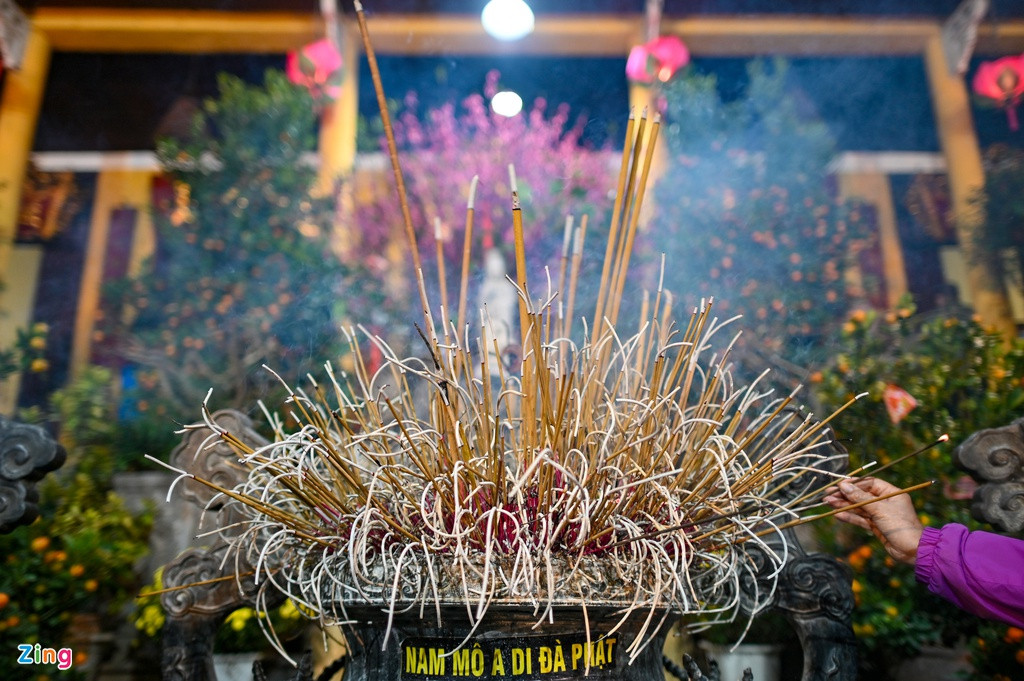 Khói bay nghi ngút trong sân chùa Quán Sứ. 3 lư hương nằm chính giữa sân chùa không còn chỗ trống, người dân phải vất vả mới tìm được chỗ để cắm hương.