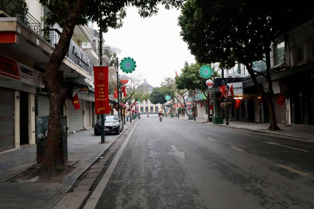 Các con phố, ngõ nhỏ của Hà Nội treo cờ đỏ sao vàng treo rực rỡ nhưng vắng người qua lại vào sáng sớm mùng 1 Tết.