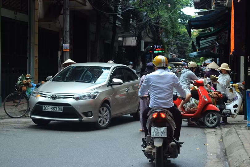 Trong khi đó, các phương tiện, thậm chí là người đi bộ phải luồn lách qua những chiếc xe bán trái cây đang chắn ngang đường để di chuyển một cách khó nhọc. Ảnh chụp tại Thanh Xuân Bắc (Quận Thanh Xuân, Hà Nội).