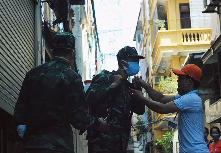 Cán bộ y tế hướng dẫn, giúp đỡ bộ đội trước khi phun hóa chất diệt muỗi phòng chống dịch bệnh sốt xuất huyết một cách an toàn theo đúng quy định.