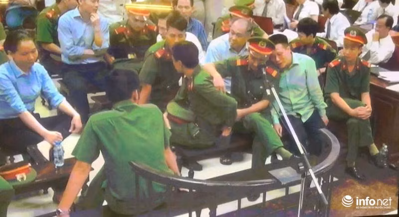 Nhiều lúc, Hà Văn Thắm - cựu Chủ tịch OceanBank gối hẳn đầu lên vai một cảnh sát để chuyện trò một cách tình cảm. Ảnh: Infonet.