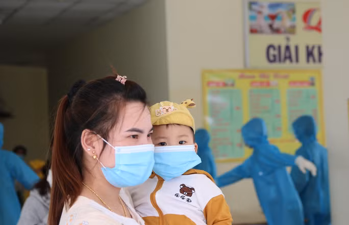 Một bé trai đi cách ly cùng mẹ tỏ vẻ thích thú khi được ra khỏi phòng sau nhiều ngày cách ly.