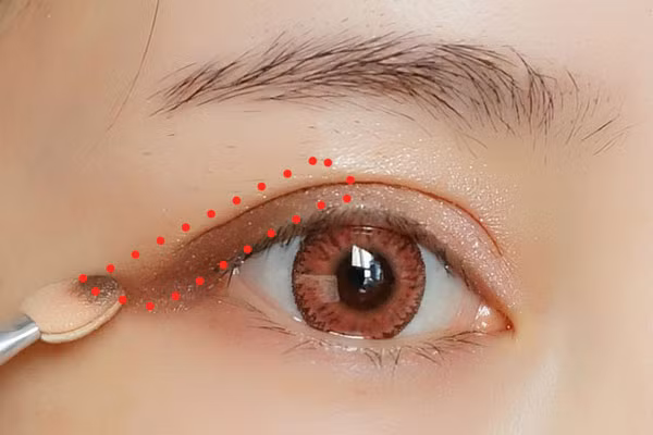 Đánh nhấn màu hồng đào phần đuôi mắt của mi trên, chải mascara cho mi trên và mi dưới thật cong.