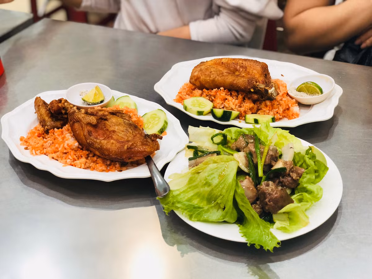 Món cơm gà nhuộm điều màu đỏ đẹp mắt, miếng gà chiên da giòn tan nhưng thịt vẫn mềm tươi ngon.