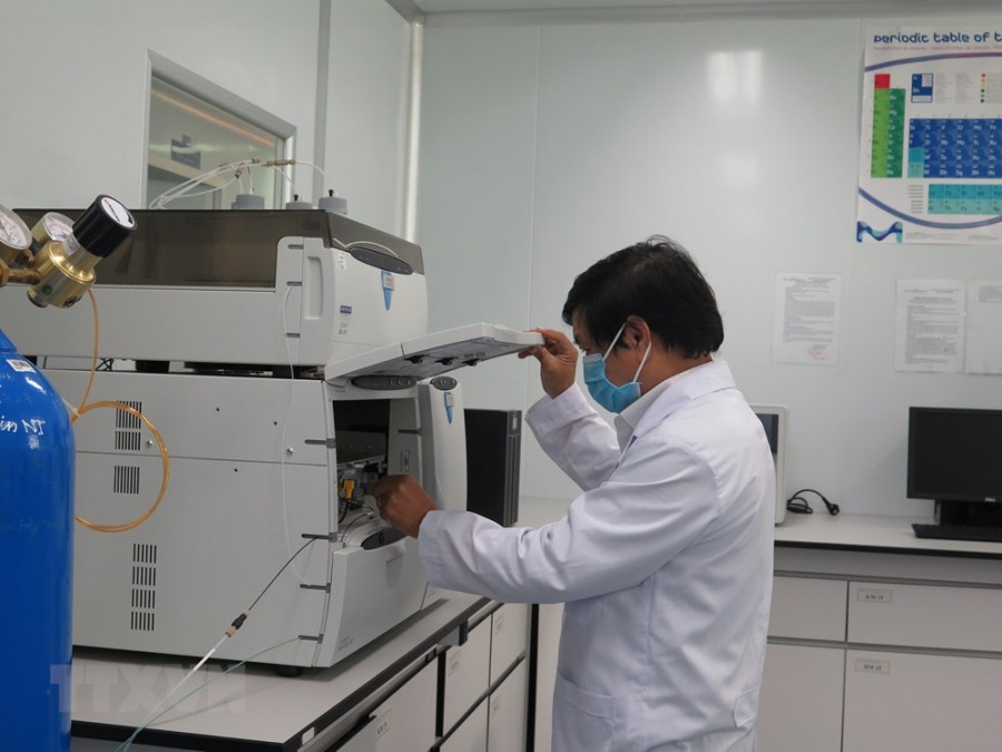 Một khâu trong kiểm định chất lượng vắc-xin Covivac.(Ảnh: TTXVN)