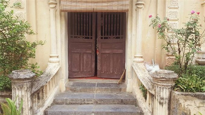 Cánh cửa làm bằng gỗ lim, mùa hè, gió thổi qua các khe thoáng giúp nhà mát mẻ. Mùa đông gia chủ hạ tấm rèm bên trong xuống giữ ấm.