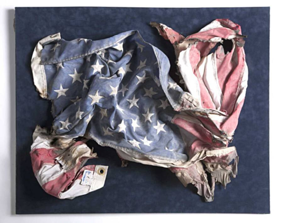 Đây là một lá cờ của Mỹ bị rách và cháy xém 1 phần do vụ khủng bố 11/9. Nó được tìm thấy tại khu vực 2 tòa tháp thuộc Trung tâm thương mại thế giới ở New York đổ sập.