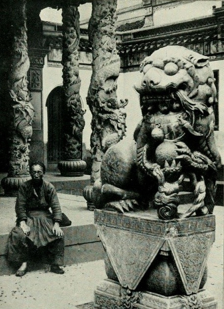 Một người đàn ông đang ngồi trên thềm đá, xét từ trang phục có thể thấy người này không giàu có. Có thể ông là người làm công cho một gia đình giàu có.