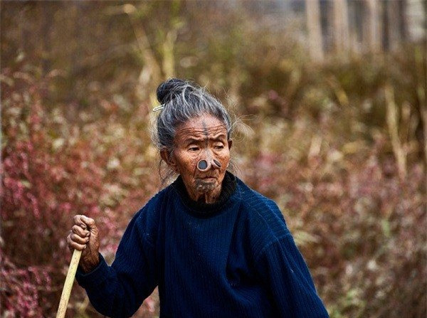 Để làm giảm sức hút trước đàn ông bộ tộc khác, phụ nữ Apatani bắt đầu đeo những chiếc nút mũi kỳ dị và xăm lên mặt khiến cho gương mặt xấu xí đi để không bị người khác chú ý nữa.