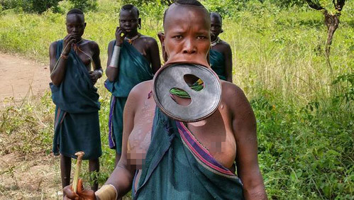 Để đeo những chiếc khuyên bằng đĩa lên vành môi dưới, những cô gái trẻ sẽ đập bỏ 2 răng dưới. Kế đến, môi dưới được rạch ra để chèn vào một căm gỗ. Căm gỗ này sẽ được thay thế bằng một miếng lớn hơn khi môi giãn ra. Cứ như vậy cho đến khi môi dưới kéo rộng có thể đặt một cái đĩa làm từ gỗ hoặc đất sét vào.