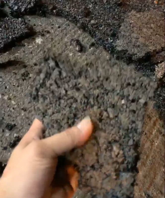 Trong đoạn clip, người đăng dùng tay bóc lớp bê tông nhựa đã hoàn thiện và dễ dàng bóp vỡ vụn.