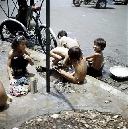 Trẻ em tắm giặt ngay trên vỉa hè.