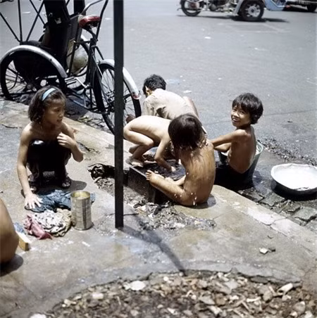 Trẻ em tắm giặt ngay trên vỉa hè.