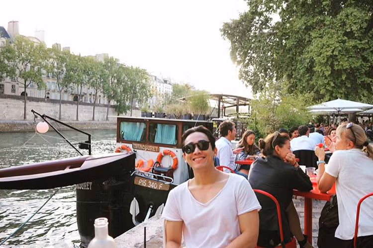 Hứa Vĩ Văn thảnh thơi ngồi ngắm cảnh sông nước ở Paris, Pháp.