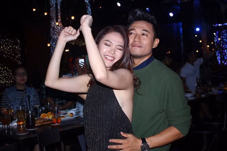 Quý Bình tình tứ ôm eo Minh Hằng trong buổi tiệc đóng máy phim “Bao giờ có yêu nhau”. Thậm chí, anh còn bế bổng người tình tin đồn lên sân khấu, bắt cô phải hát vì đến muộn. Ảnh: Zing