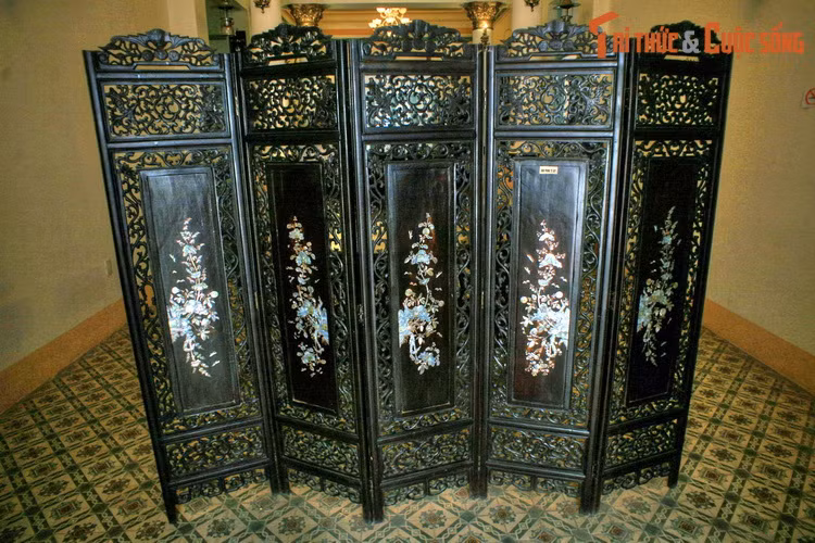 Một bộ bình phong chạm khảm cầu kỳ phân chia không gian trong dinh thự.