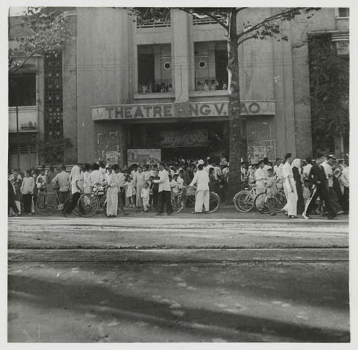 Tết cổ truyền không chỉ là điều mang ý nghĩa thiêng liêng với người Việt từ bao đời nay, mà đó còn là thứ hấp dẫn, gây tò mò với nhiều du khách nước ngoài. Trong khoảng từ năm 1920-1950, nhiều nhiếp ảnh gia nước ngoài đã tới thủ đô Hà Nội và Sài Gòn tận hưởng không khí Tết đặc biệt của người dân và ghi lại những khoảnh khắc hiếm có. Ảnh: Tết tại Sài Gòn năm 1949 - Rạp Nguyễn Văn Hảo trên đại lộ Galliéni (nay là Trần Hưng Đạo). Vào ngày Tết, giới trẻ thời đó thường đi xem phim hoặc xem cải lương.