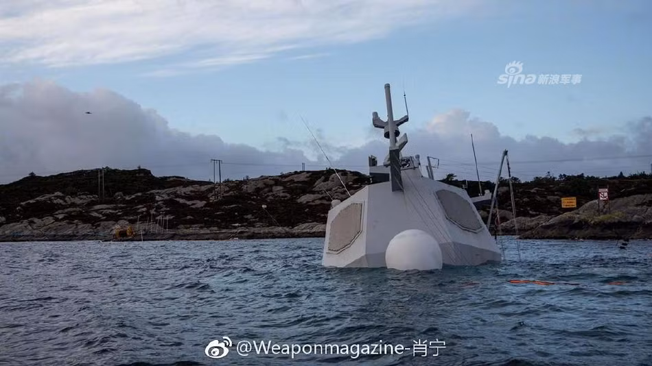KNM Helge Ingstad không những đang tiếp tục trượt sâu xuống vực biển nằm ngay cạnh bãi đá mà nó còn bị "tấn công" bởi thủy triều ở khu vực vịnh Hjeltefjord khiến mọi nỗ lực trục vớt con tàu này của Hải quân Na Uy đều trở nên vô ích. Nguồn ảnh: Sina.