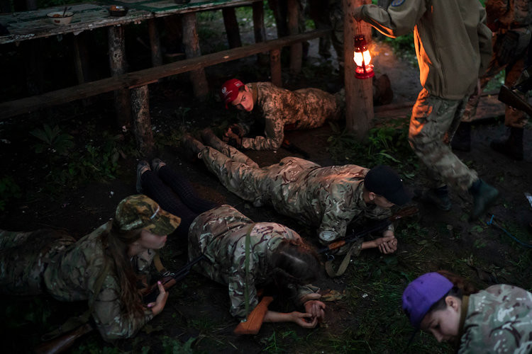 Bài học lăn lê bò toài với trang bị vũ khí là súng trường AK-47 dành cho các học viên trong trại huấn luyện chủ nghĩa dân tộc ở Ukraine. Nguồn ảnh: BI.