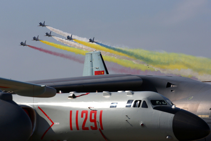 Máy bay ném bom H-6K ở bên dưới và đội bay Hồng Ưng nhả khói phía trên trời. Nguồn ảnh: TASS.