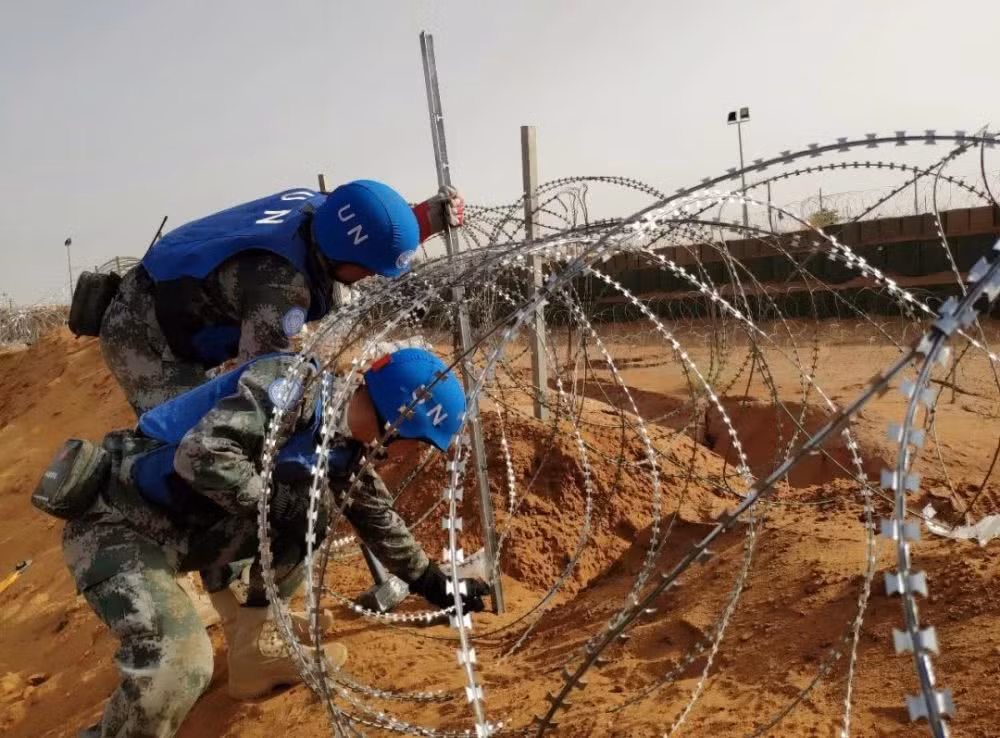 Lực lượng gìn giữ hoà bình Trung Quốc kiểm tra lại hệ thống hàng rào xung quanh doanh trại vào buổi sáng sau vụ tấn công khủng bố giết chết 8 người địa phương - có vẻ vụ tấn công không nhắm vào doanh trại của Trung Quốc đặt tại đây. Nguồn ảnh: QQ.