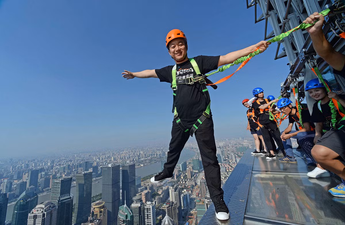 Du khách treo mình trên con đường kính nằm ở tầng 88 tòa Tháp Kim Mậu, Thượng Hải. Ảnh: Theatlantic.
