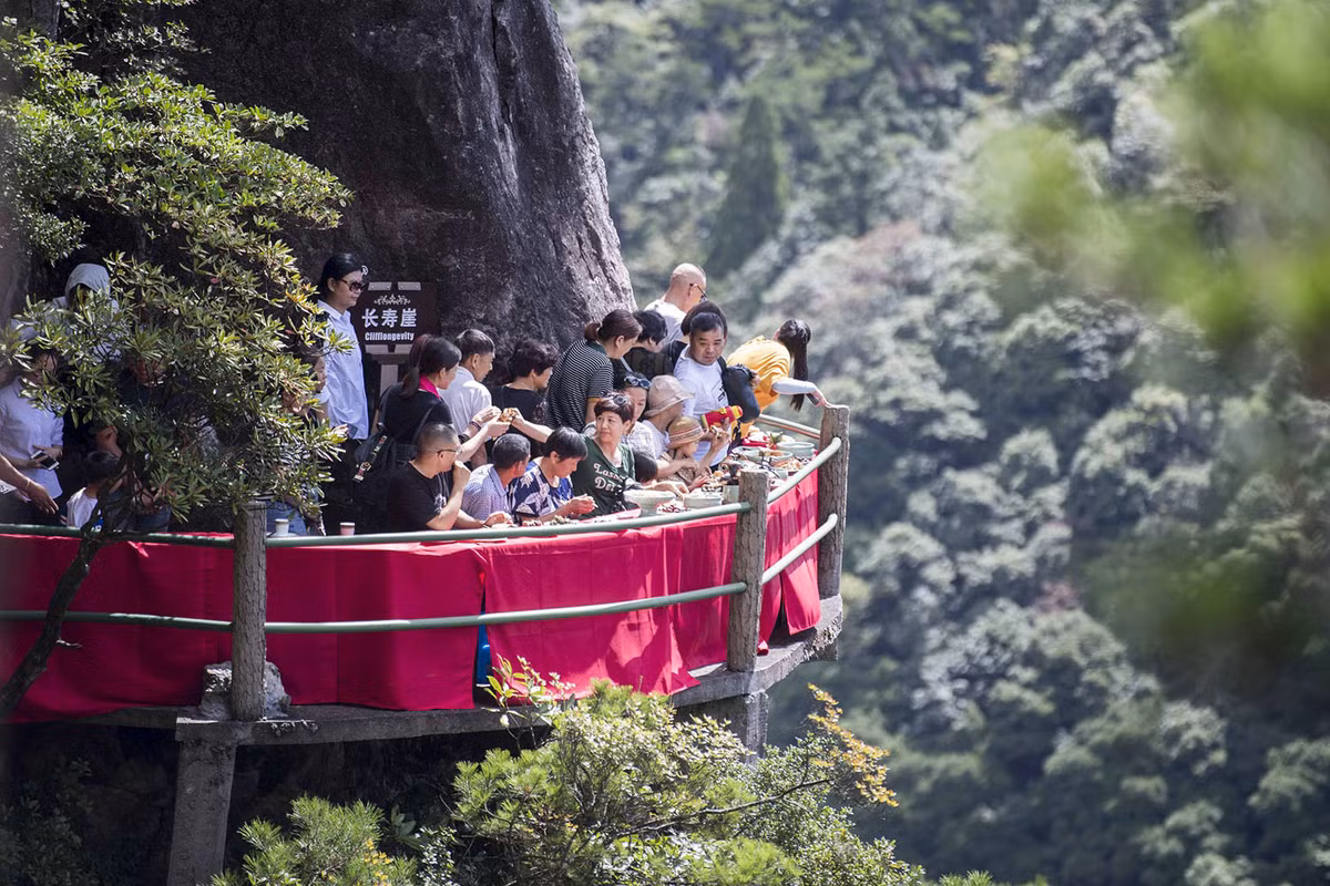 Thậm chí còn có cả nhà hàng đặt ở độ cao chênh vênh phục vụ bữa ăn trưa cho du khách. Trong ảnh, du khách đang thưởng thức bữa trưa tại núi Long Tuyền, Chiết Giang, Trung Quốc. Ảnh: Theatlantic.