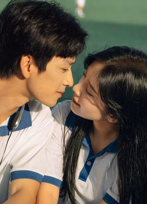 Cả hai mặc đồng phục học sinh, trao nhau cử chỉ, ánh mắt đầy ngọt ngào.