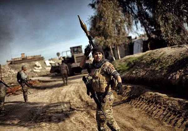 Binh sĩ Iraq và xe quân sự Iraq đang tiến sâu vào các khu vực ở Tây Mosul còn nằm trong tay nhóm IS. Ảnh FNA