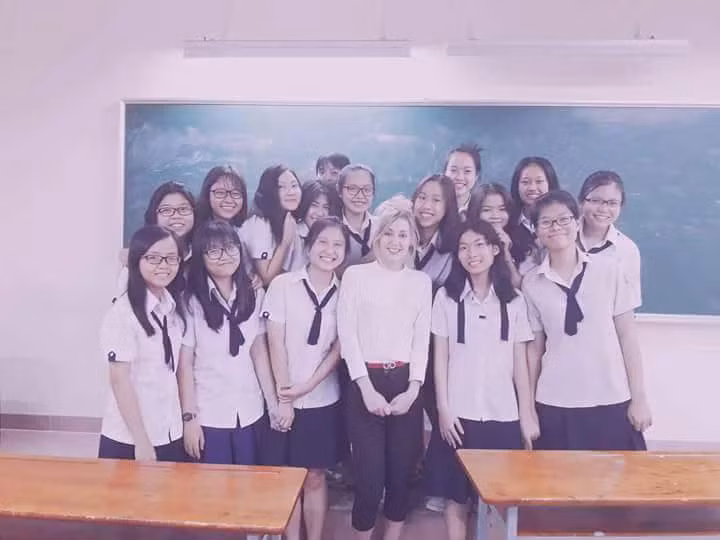 Theo tìm hiểu, cô giáo ngoại quốc xinh đẹp đang làm đảo điên mạng Việt tên thật là Imogen Faye Louise Cox, đến từ thành phố Norwich nước Anh, hiện đang là giáo viên dạy tiếng Anh tại trường THPT Nguyễn Chí Thanh, quận Tân Bình, TP HCM. Với các bạn học sinh cấp 3 ở Việt Nam, việc được dạy bởi các giáo viên ngoại quốc vẫn chưa phải phổ biến, nhất là được học lớp của một cô giáo người Anh xinh đẹp như cô Imogen lại càng là một điều hiếm hoi.