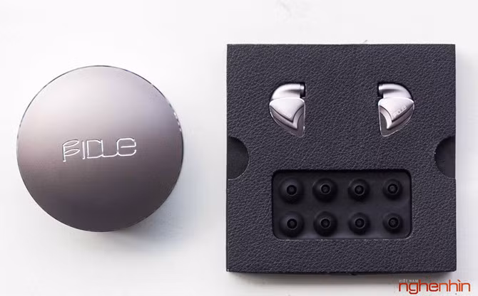 Nhấc tấm đệm bọc da lên sẽ thấy một hộp kim loại hình trống. Đây là hộp đựng tai nghe và phụ kiện khá rộng rãi và được thiết kế cao cấp với đường viền cắt kim cương.