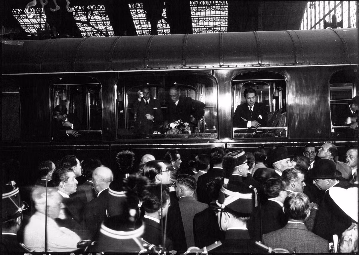 Dân Paris ngắm hoàng đế Bảo Đại ở nhà ga thành phố khi chuyến tàu hỏa chở ông vừa đến. Trong ảnh, Bảo Đại là người khoanh tay ở ô cửa sổ bên phải toa tàu.