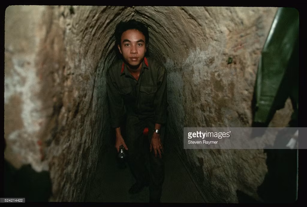 Hướng dẫn viên người Việt đưa du khách xuống khám phá một địa đạo ở khu di tích Củ Chi.