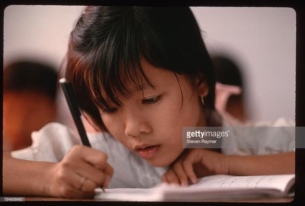 Một em bé từng là trẻ em đường phố trong lớp học tại một trại trẻ mồ côi ở TP HCM.