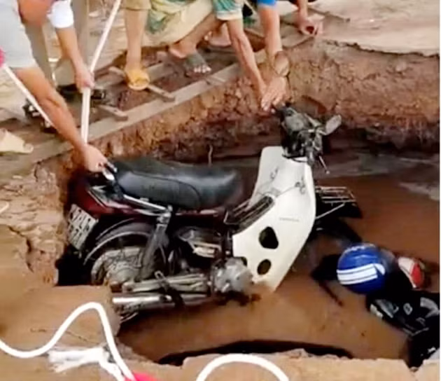  Hố tử thần xuất hiện trong trường học "nuốt chửng" nhiều xe máy: Trước đó, ngày 29/5/2020, tại Trường Tiểu học Trần Quốc Toản (xã Ya Tờ Mốt, huyện Ea Súp, tỉnh Đắk Lắk) đã xuất hiện hố tử thần khiến 2 chiếc xe máy bị rơi xuống hố sâu. Rất may, thời điểm bị sụt lún giáo viên và học sinh đã vào lớp nên không thiệt hại về người. Thời điểm hố vừa sụt chỉ là một hố nhỏ phía bên dưới nước dâng lên. Đến sáng hôm sau, hố này đã bị lở dần, lan rộng ra hơn 5m.(Ảnh: Bảo vệ pháp luật)