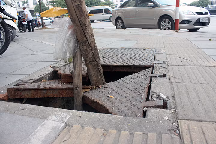 Hố tử thần chực "nuốt chửng" người đi bộ: Cuối năm 2018, trên vỉa hè đường Trung Kính ( Hà Nội), một hố ga lớn bị gãy nắp, trống hoác, nhìn rõ đáy đã khiến không ít người "sa bẫy". Theo ông Bùi Quang Lánh, nhân viên bảo vệ một cửa hàng ngay tại đoạn vỉa hè này cho biết, hố tử thần này đã có từ gần 2 năm nay, khiến không ít người và phương tiện bị tai nạn. (Ảnh: VOV)
