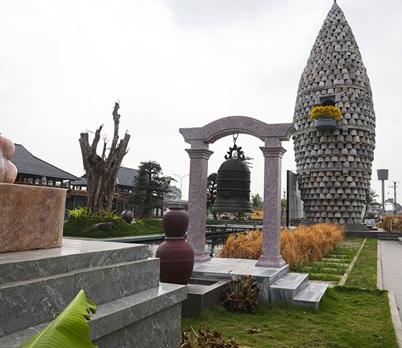 Với chiều cao 15m và chia thành 5 tầng, tháp Thần Nông được ghép bởi 1.012 cối đá xếp vòng ngoài. Bên trong tháp là khung cột bê tông được đổ kiên cố. Ảnh: Báo Tin Tức.