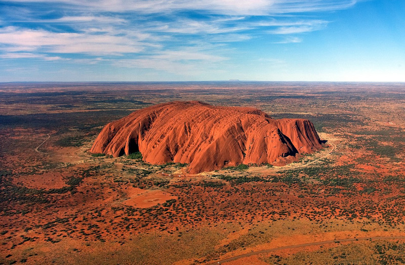 Chiều cao của núi Uluru là khoảng 348m, dài 3 km và chu vi chân núi khoảng 8,5 km. Nhìn từ xa, đây là một khối đá khổng lồ và bóng nhẵn. Điều thú vị và kỳ lạ là núi Uluru có khả năng tự biến đổi màu sắc tùy theo thời tiết, khoảng thời gian trong ngày. Ảnh: Corey Leopold CCL.