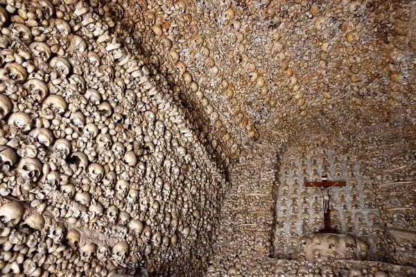 Nhà nguyện cốt ở Bồ Đào Nhà được xây dựng bằng xương của hơn 5.000 tu sĩ. Trong số đó, hai bộ hài cốt hoàn thiện của một người lớn và một trẻ em được giăng lên tường. Ảnh: Pinterest.