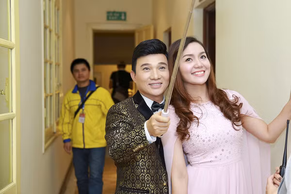 Quang Linh và Ngọc Anh chụp ảnh kỷ niệm bằng gậy selfie. Ảnh: Hải Bá.