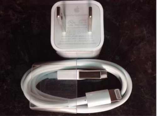 Để nhận biết sạc iPhone chính hãng, có thể dựa vào độ sắc nét của chữ trên sạc. Các nét chữ trên củ sạc iPhone chính hãng thường thanh mảnh, sắc nét, dễ đọc. Ảnh: Cnet.