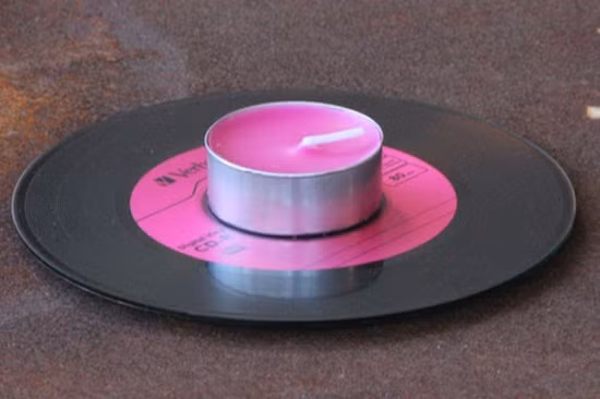 Đặt nến lên trên những chiếc đĩa CD đầy sắc màu vừa để trang trí nhà cửa thêm sinh động, vừa tạo ra một khay cầm tiện dụng. Ảnh: Makeuseof.